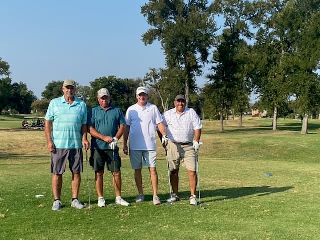 A foursome poses on the tee box before their round