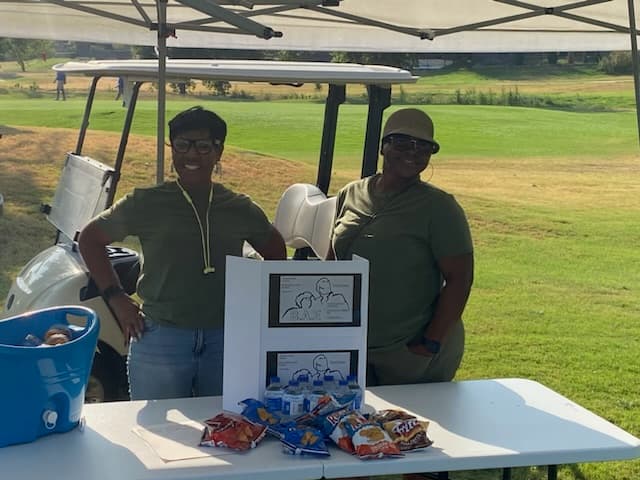 Volunteers staff the snack tent beside the fairway