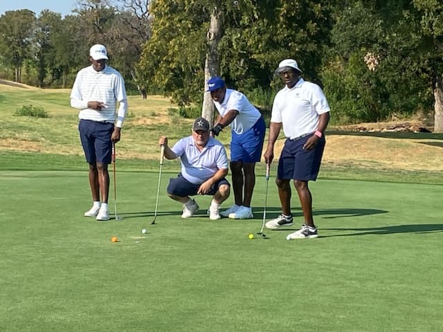 Players line up a putt on the green