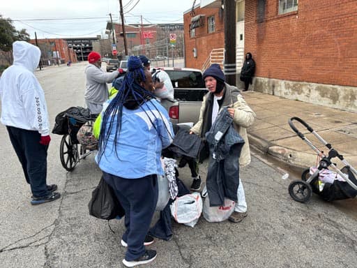 Handing out clothing from the back of a pickup on a cold morning