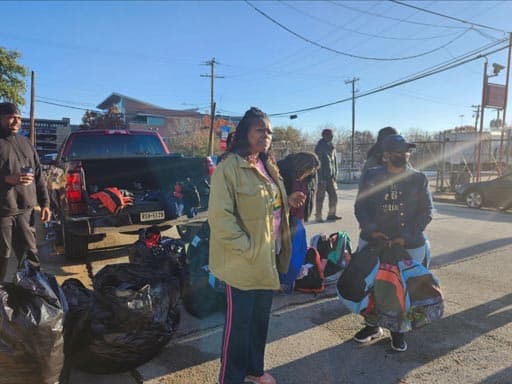 Volunteers carry bags of donations to the distribution point