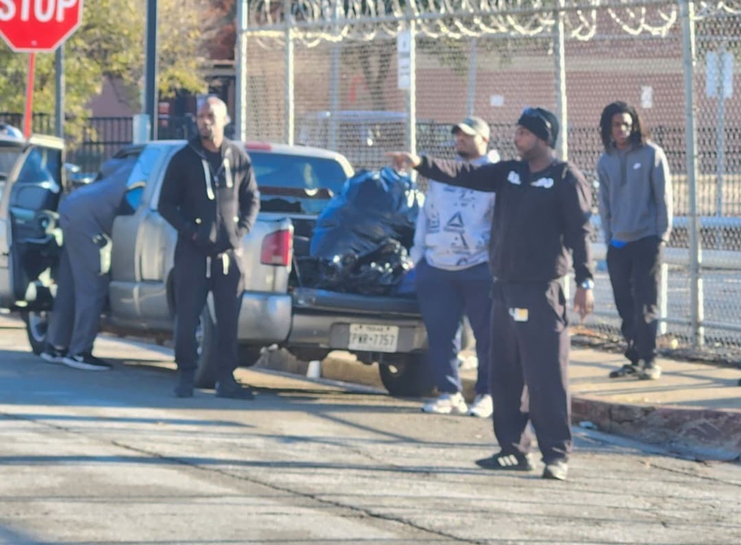 Neighbors receive bags of supplies beside the truck